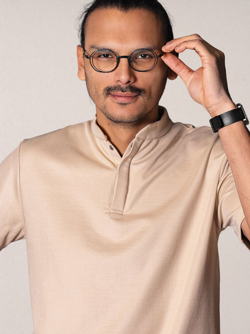 polo Simba beige porté par Esteban