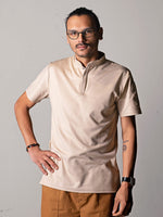 polo Simba beige porté par Esteban