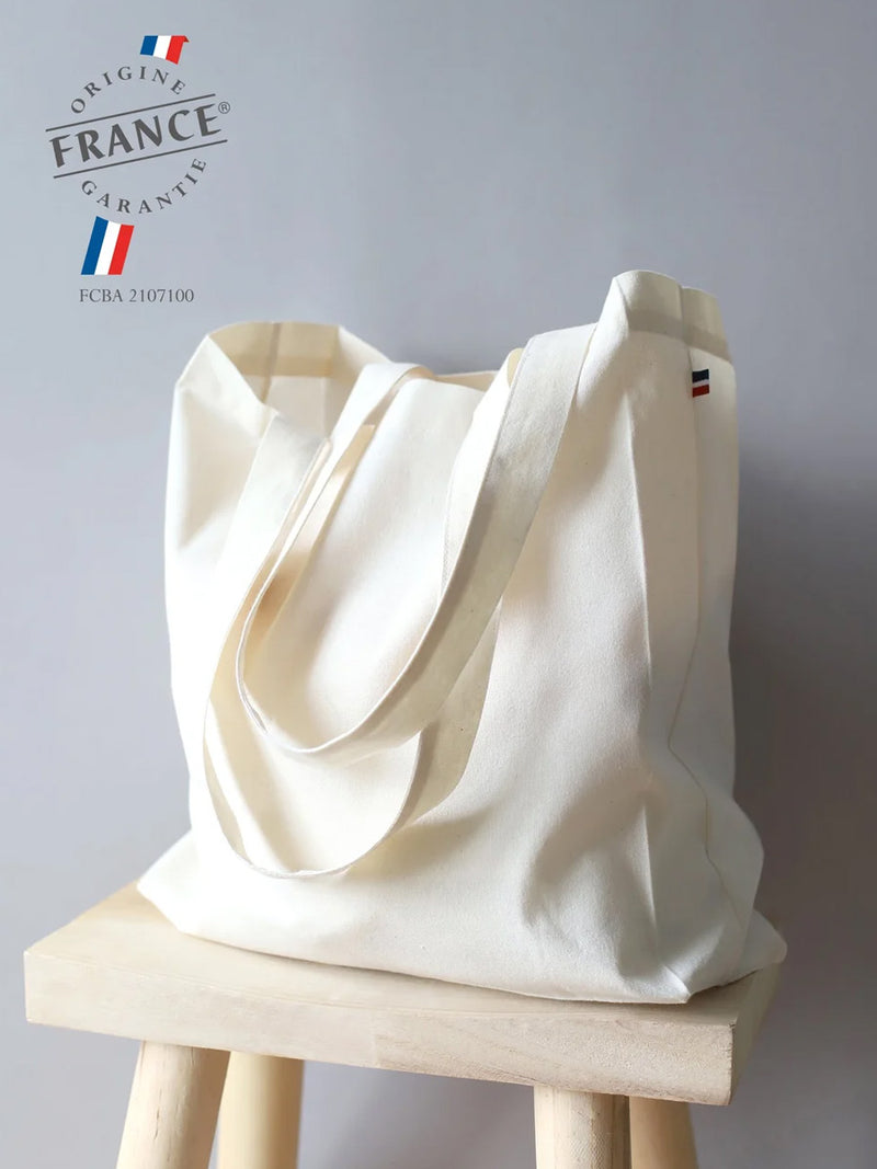 sac Tristan écru posé sur un tabouret